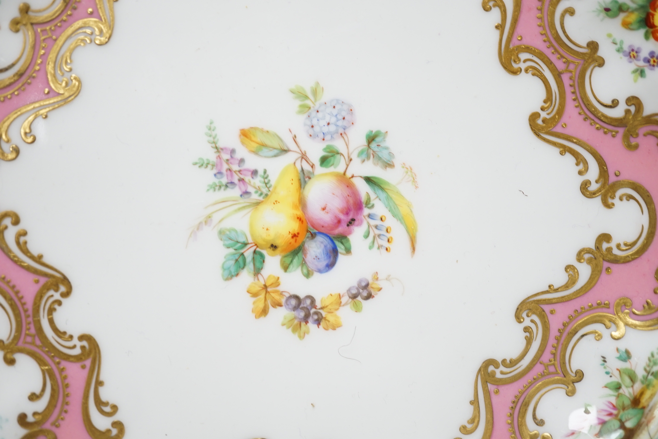 A Coalport plate painted with pink ground border, having alternating bird and flower panels and the centre with fruit and flowers, probably by Randall and Cook